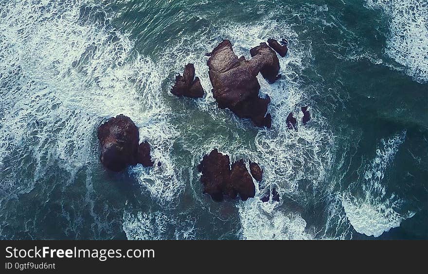 An aerial view of sea water splashing against rocks, California.