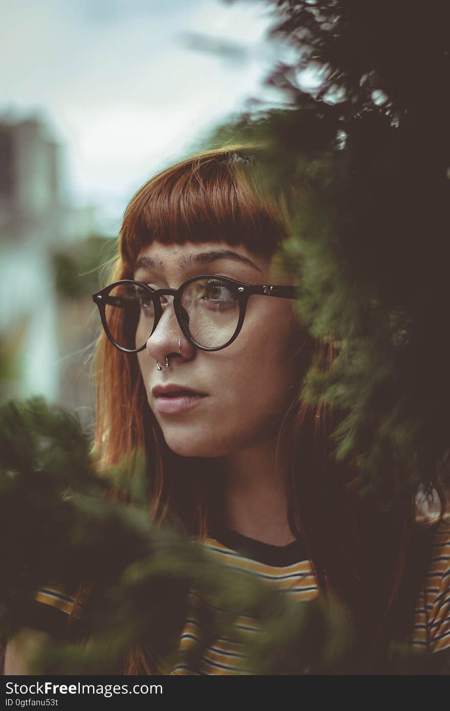 A portrait of a woman with a septum piercing and eyeglasses. A portrait of a woman with a septum piercing and eyeglasses