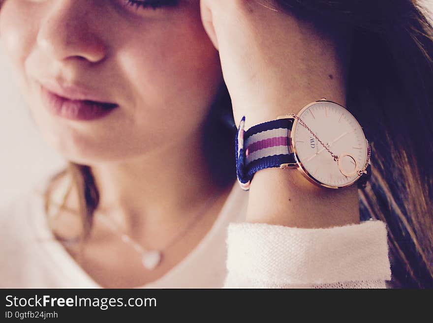 Closeup portrait of girl (part of face shown) showing wrist watch with colorful strap and showing sad tearful expression on girl's face. Closeup portrait of girl (part of face shown) showing wrist watch with colorful strap and showing sad tearful expression on girl's face.