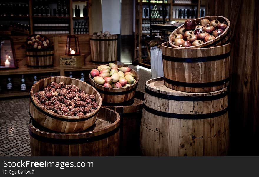 Kegs with fruits on barrels in a basement.