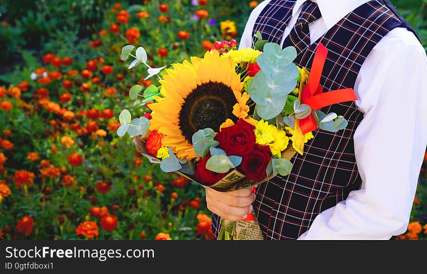 A boy holding a bouquet of flowers. A boy holding a bouquet of flowers.