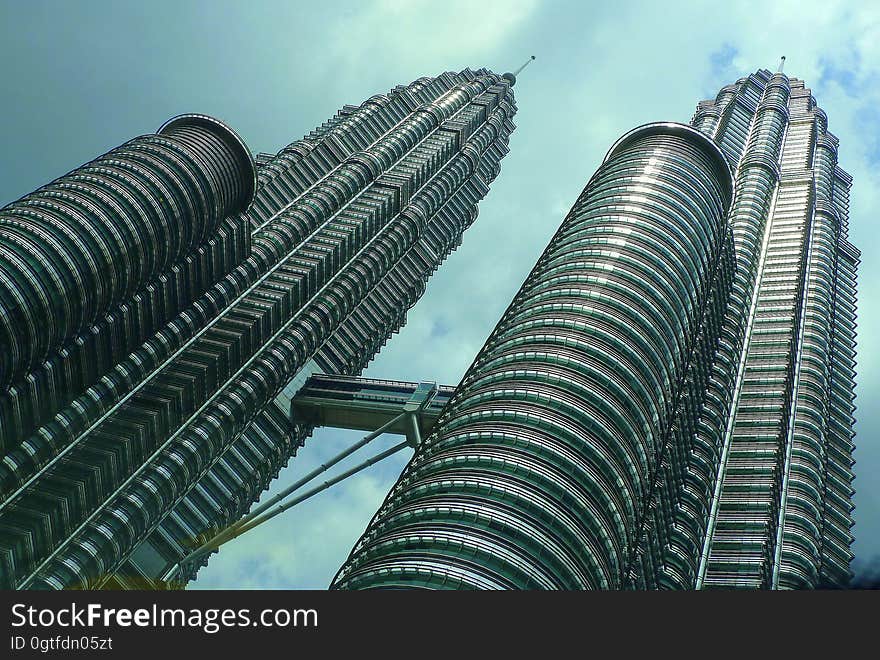 Low angle of twin skyscraper Petronas Towers against blue skies in Malaysia. Low angle of twin skyscraper Petronas Towers against blue skies in Malaysia.