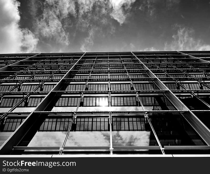 Low angle black and white view looking up side of modern skyscraper building. Low angle black and white view looking up side of modern skyscraper building.