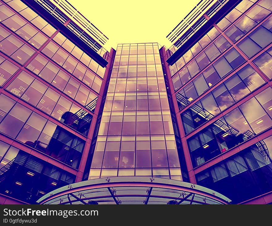 Modern downtown office building with city skyline reflecting in windows.