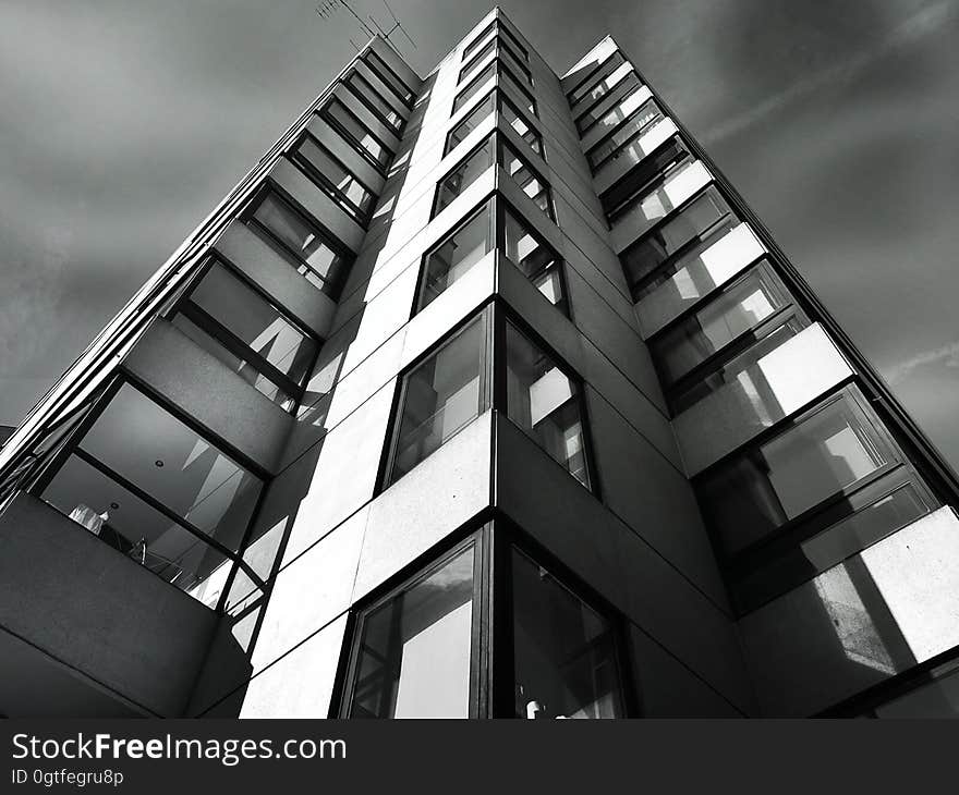 Skyscraper facade in black and white against cloudy skies. Skyscraper facade in black and white against cloudy skies.