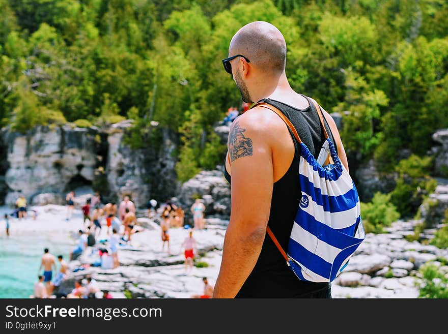 A man with a rucksack looking at a beach. A man with a rucksack looking at a beach.