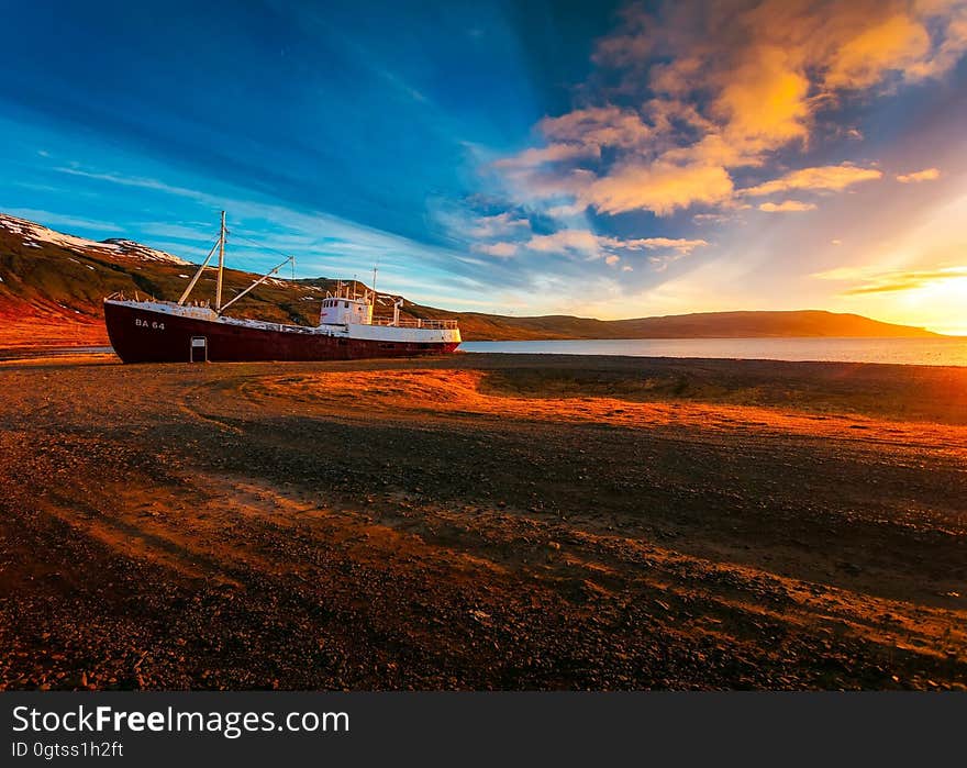 A sunset on a beach with a ship drawn ashore. A sunset on a beach with a ship drawn ashore.