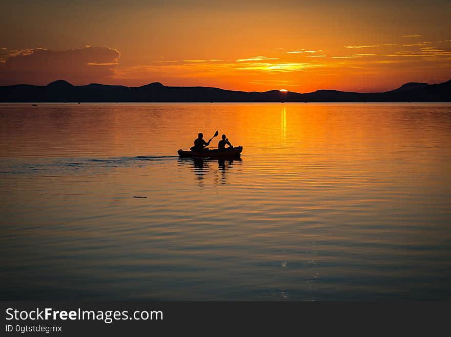 2 Person on Boat Sailing in Clear Water during Sunset