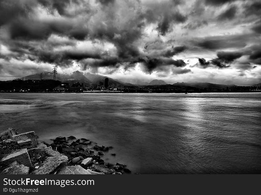 Grayscale Photo of Sea during Cloudy Sky at Daytime