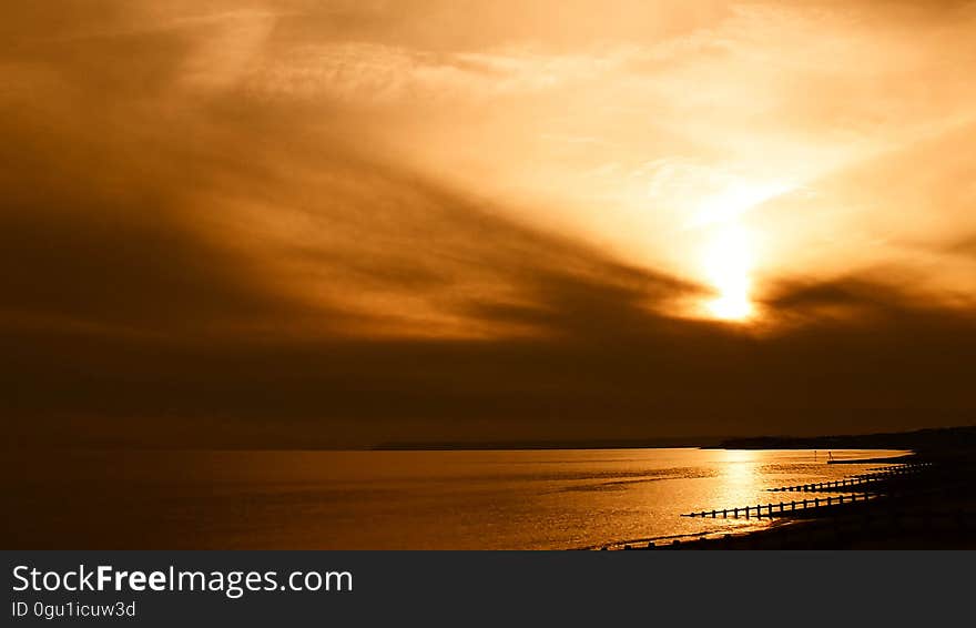 Sunset in orange skies over coastline. Sunset in orange skies over coastline.