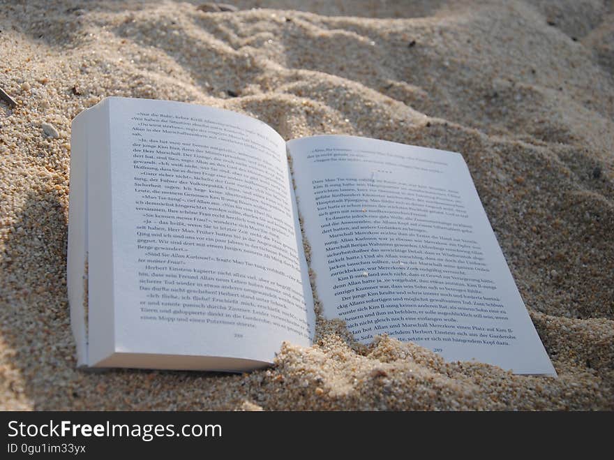 White Book on Sand during Daytime