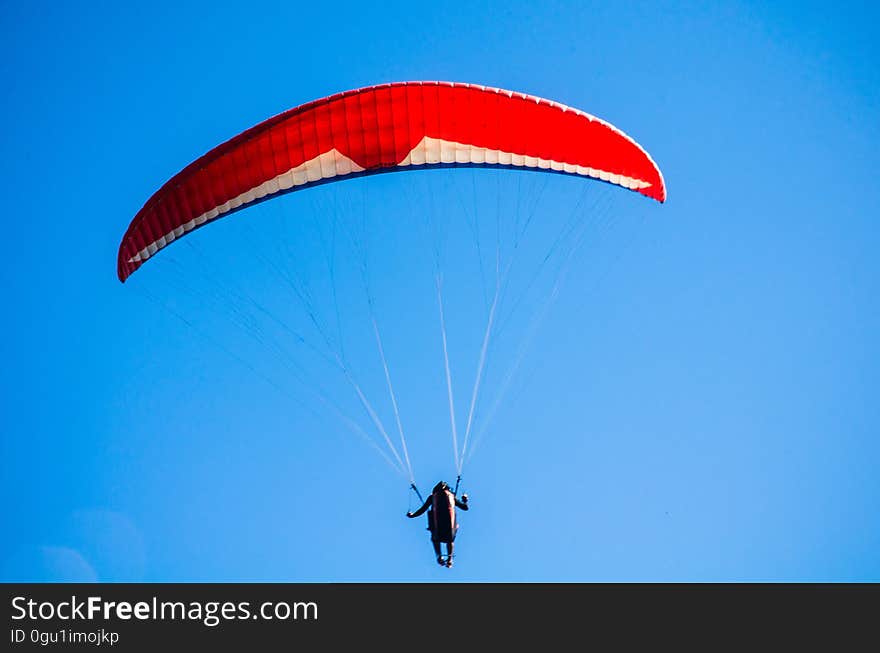 Person Using Red Parachute on Mid Air