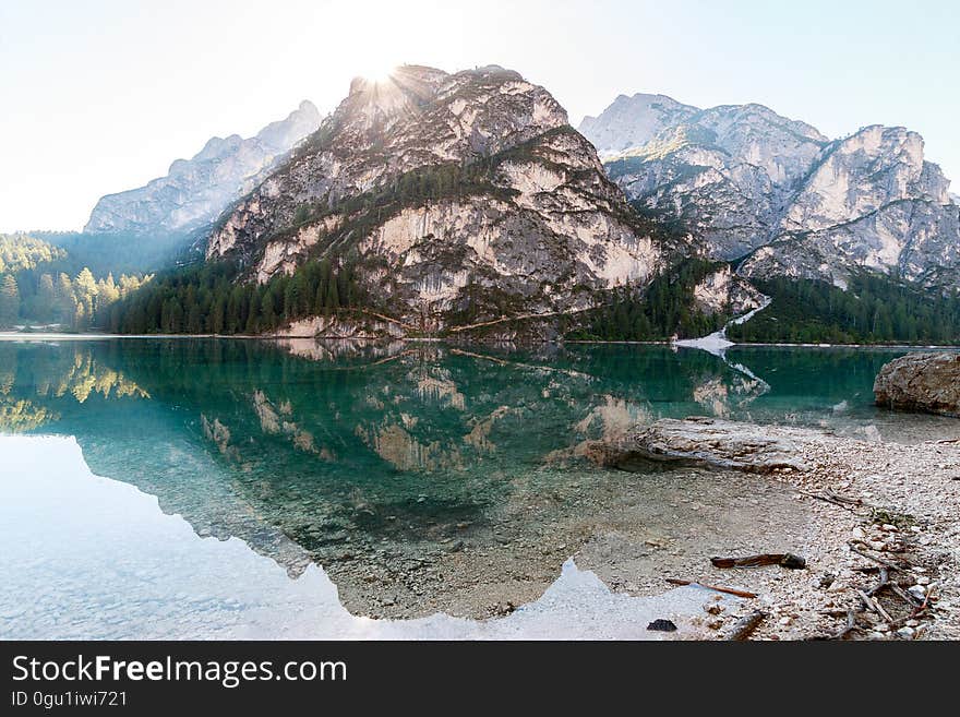 Boulder reflecting in clear waters of alpine lake on sunny day. Boulder reflecting in clear waters of alpine lake on sunny day.