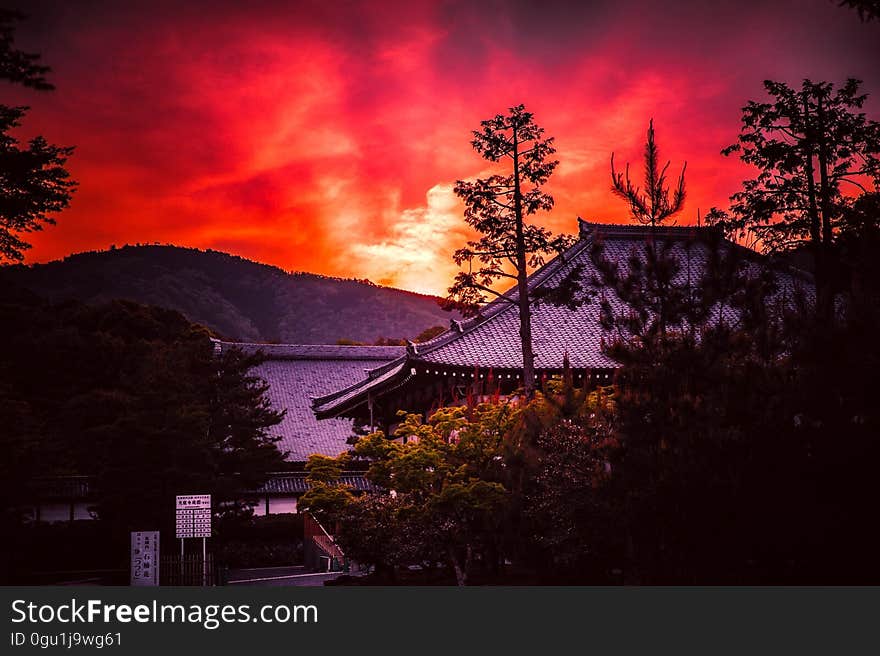 Sunset over rooftops in a traditional Asian city.