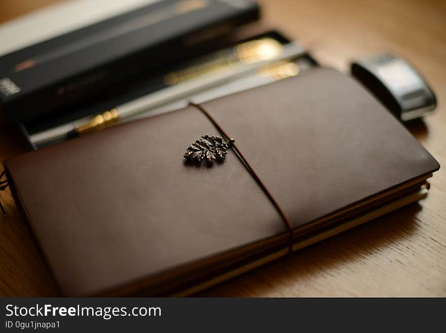 A journal and writing supplies on a desk. A journal and writing supplies on a desk.