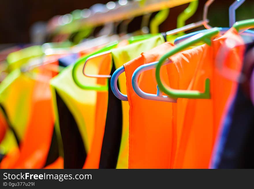 Colorful life jackets hanging on a bar, ready to be used for saving many people`s lives. Colorful life jackets hanging on a bar, ready to be used for saving many people`s lives.