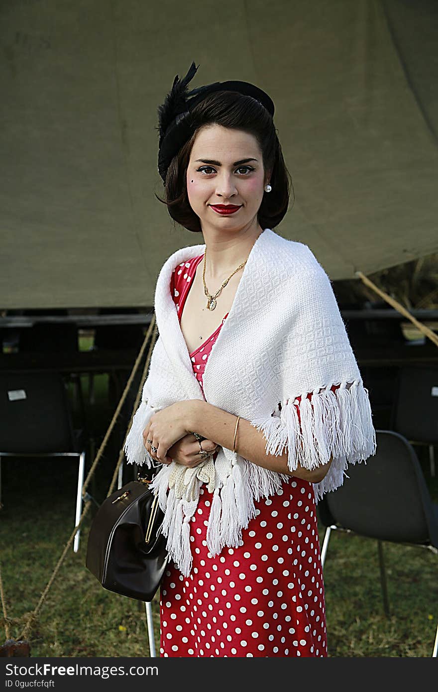 A woman with a 20s outfit including a polka dot dress and white shawl. A woman with a 20s outfit including a polka dot dress and white shawl.