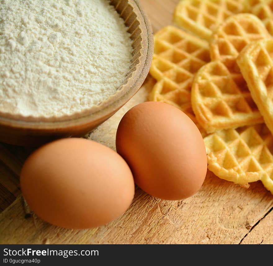 Stack of waffles with eggs and flour on a table. Stack of waffles with eggs and flour on a table.