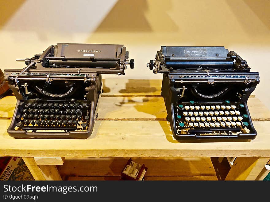 A pair of vintage typewriters on table.