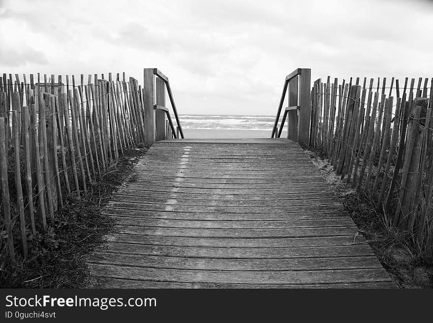 A boardwalk on a beach photographed in black and white. A boardwalk on a beach photographed in black and white.