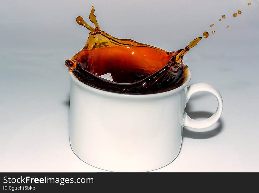 Coffee Splashing in Cup Against White Background