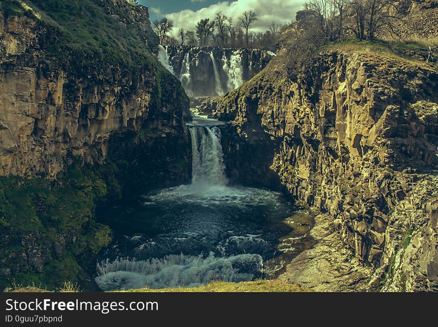 A waterfall between rocks in the wild.