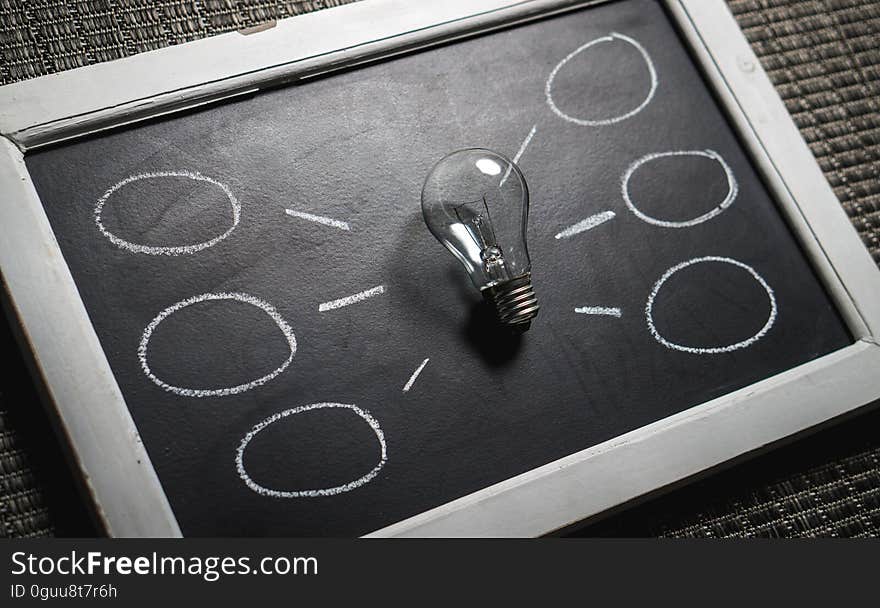 A light bulb on a blackboard with a chalk drawing symbolizing an idea. A light bulb on a blackboard with a chalk drawing symbolizing an idea.