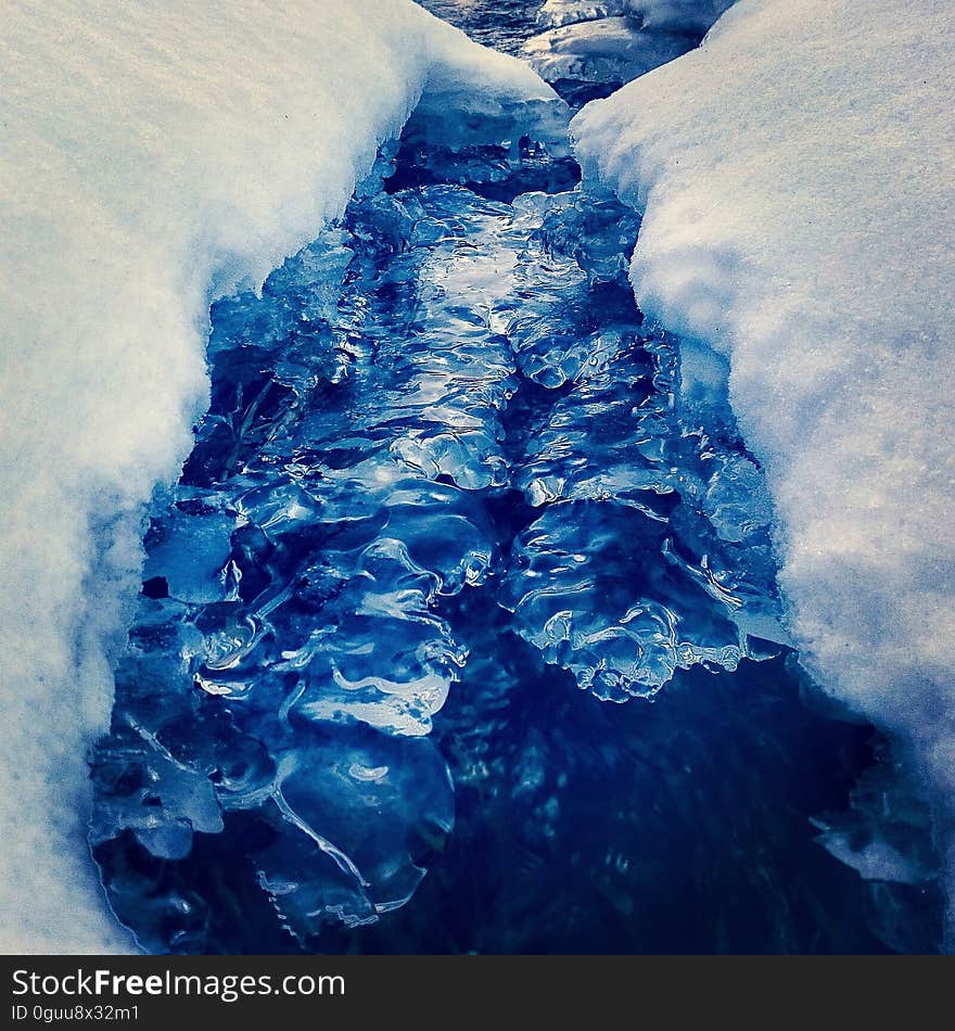 Closeup of a glacier crevasse filled with water.