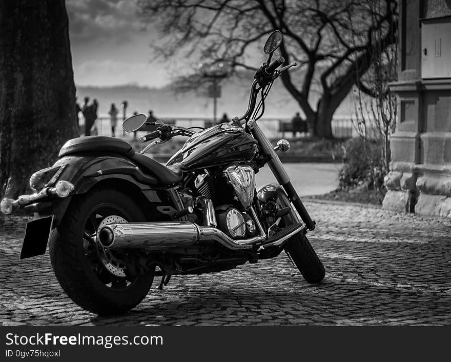 A motorcycle parked on a street in black and white photo. A motorcycle parked on a street in black and white photo.