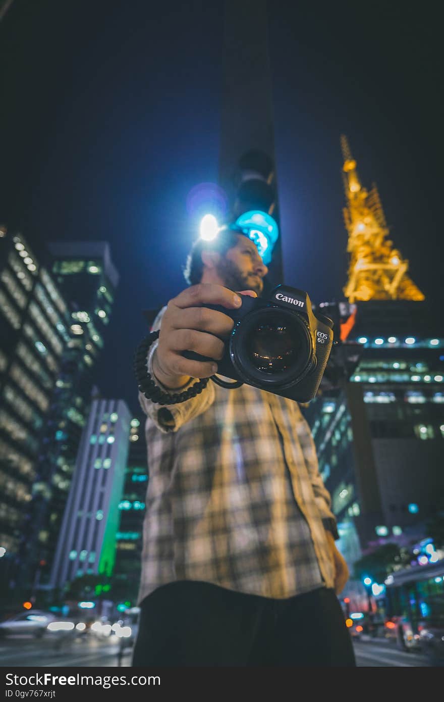 A man pointing a camera downwards. A man pointing a camera downwards.