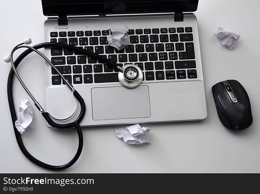 A laptop with stethoscope and mouse.