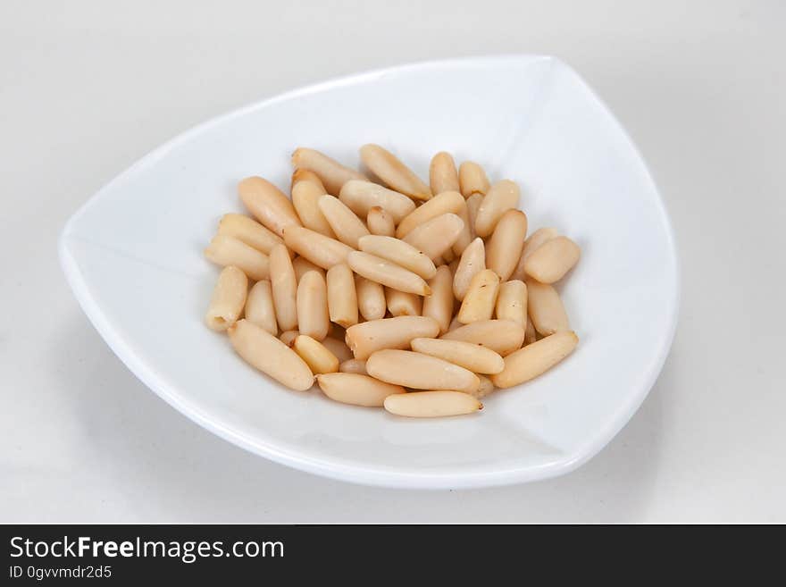 Closeup of a dish of pine nuts.