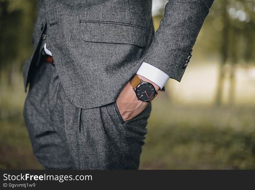 A businessman with a wristwatch holding his hand in the pocket. A businessman with a wristwatch holding his hand in the pocket.