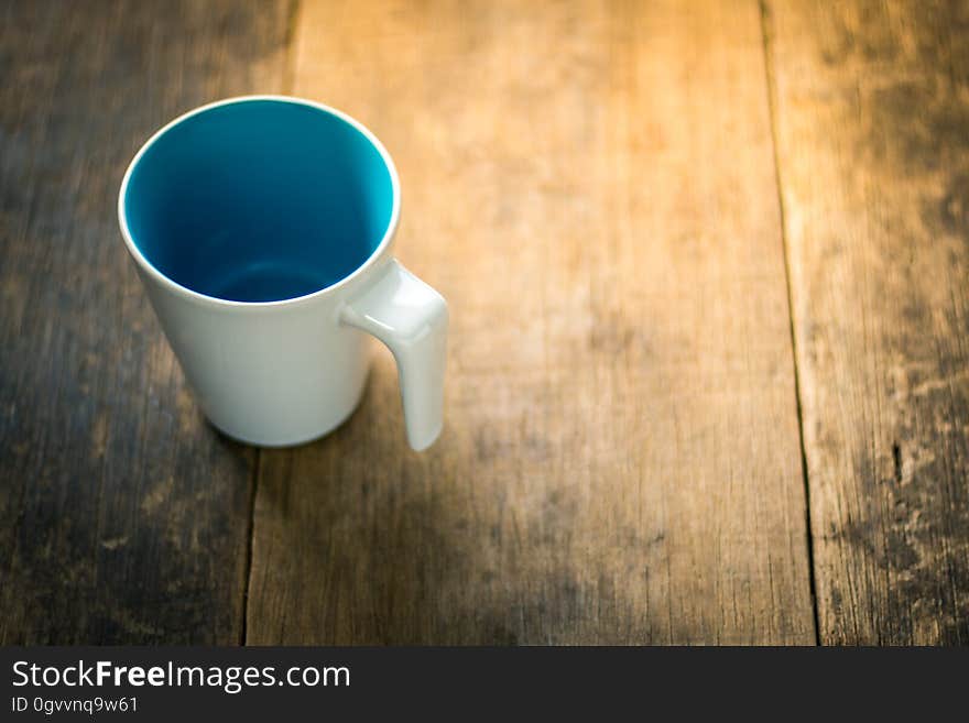 A porcelain cup on a wooden table. A porcelain cup on a wooden table.