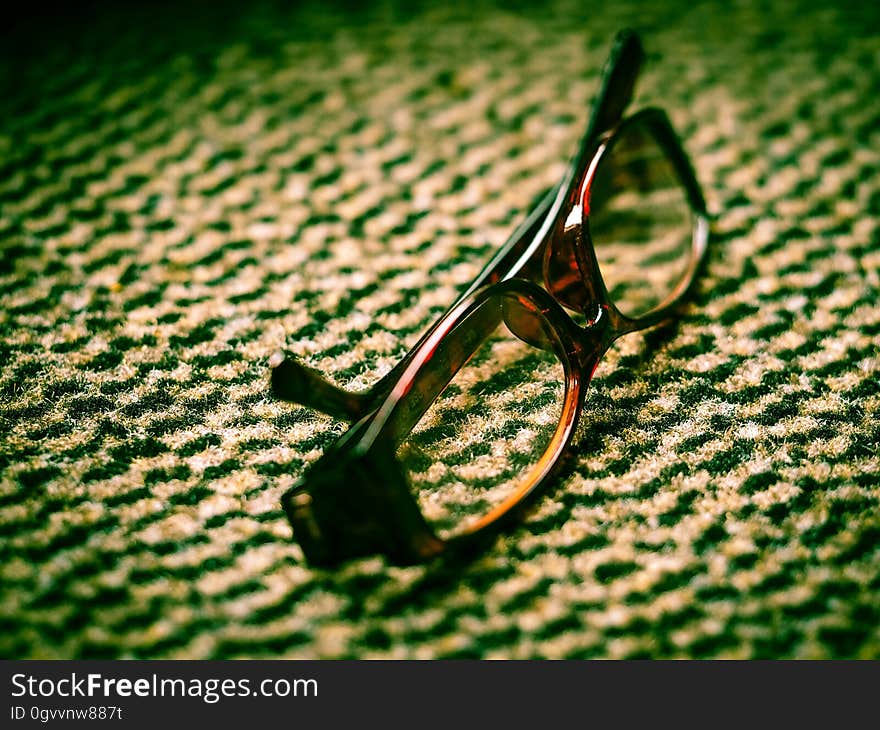 Close-up of eyeglasses with brown frame lying on a business carpet. Close-up of eyeglasses with brown frame lying on a business carpet.