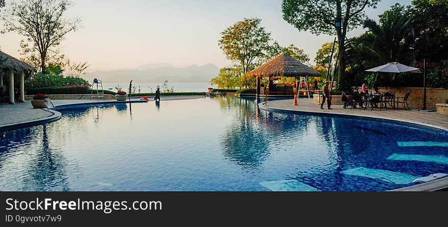 A luxury hotel swimming pool with a bar next to it.