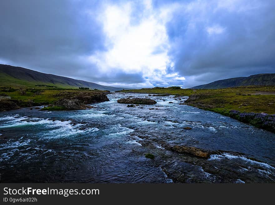 A river with rapids flowing through a valley. A river with rapids flowing through a valley.