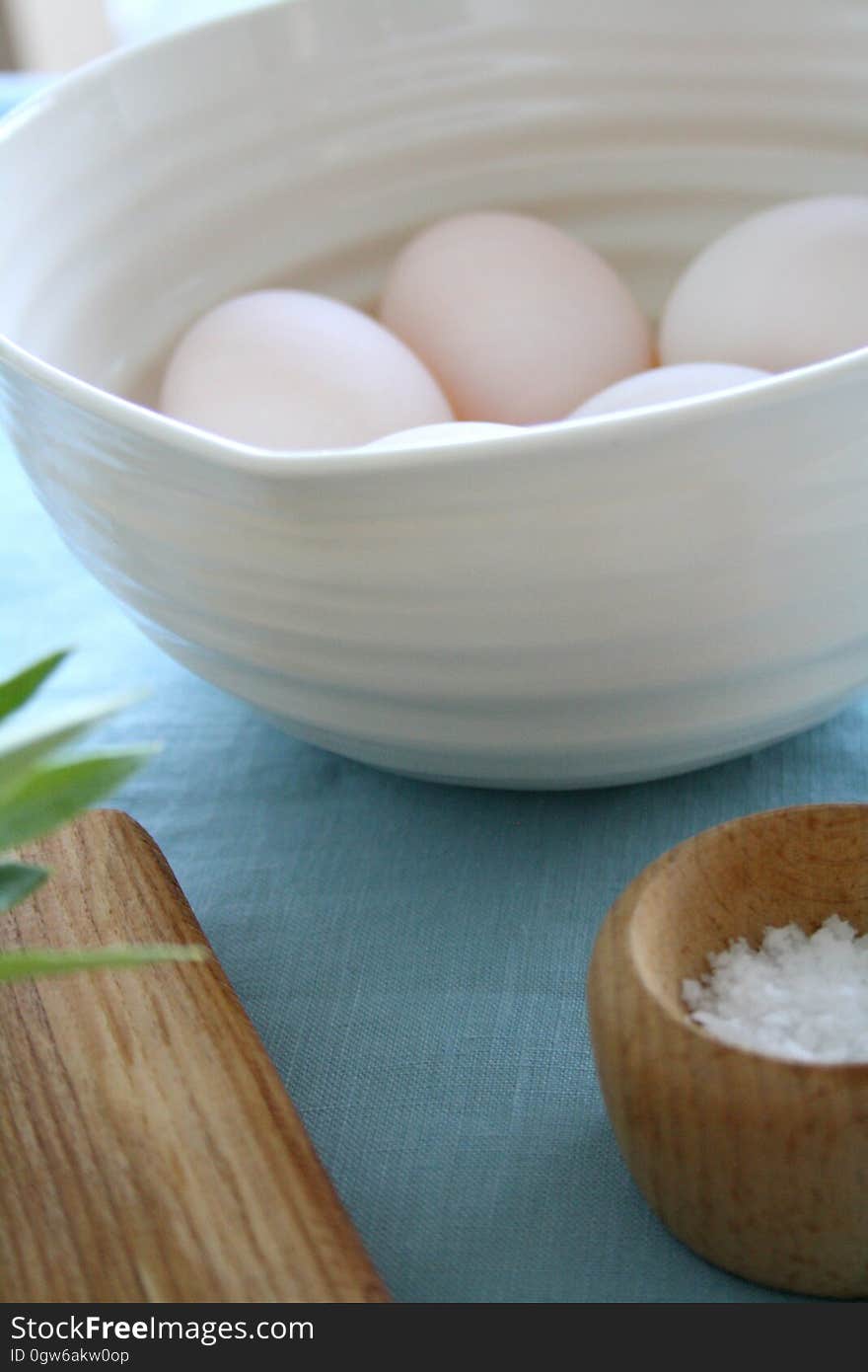 A bowl of eggs and a small cup of finger salt. A bowl of eggs and a small cup of finger salt.