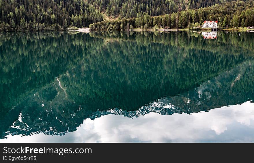 A mountain range and conifer forest reflection on the surface of water. A mountain range and conifer forest reflection on the surface of water.