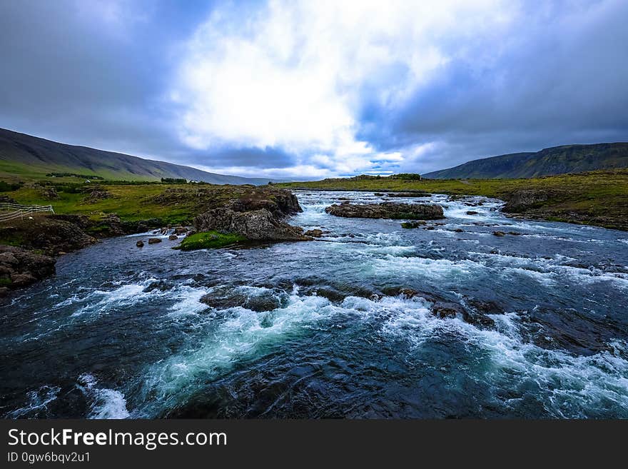 Rapids in river with green banks from aerial perspective with blue skies. Rapids in river with green banks from aerial perspective with blue skies.