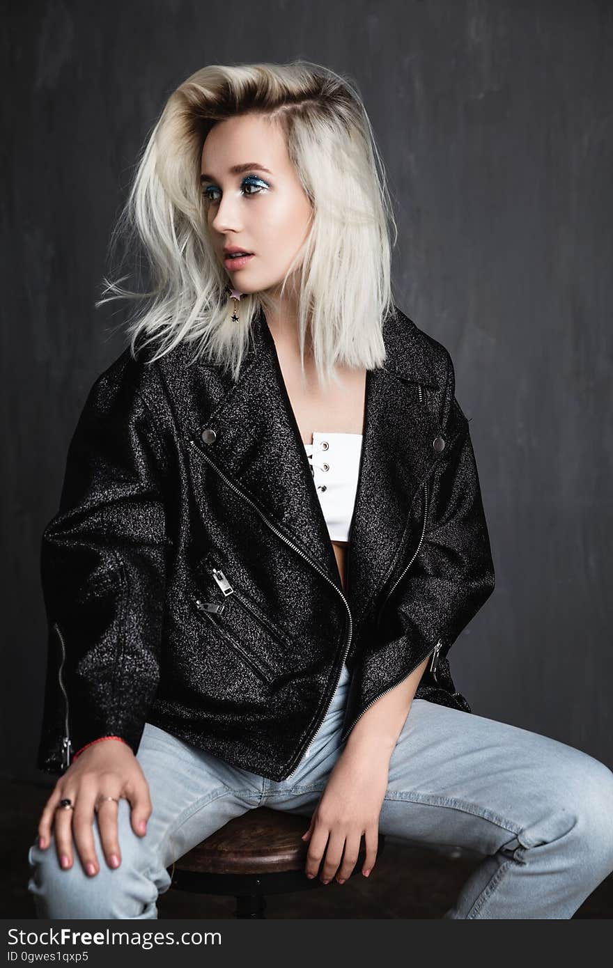 A blonde woman sitting on a chair. A blonde woman sitting on a chair.