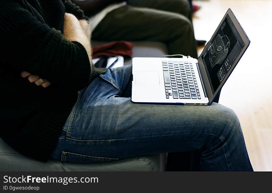 A close up of a laptop in the man's lap. A close up of a laptop in the man's lap.