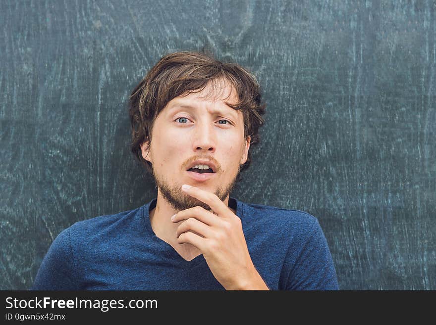 Top view of a young man with space for text and symbols on the old wooden background. Concept for confusion, brainstorming and choice.