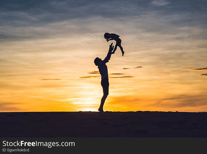 Father and son at the red desert at dawn. Traveling with children concept.