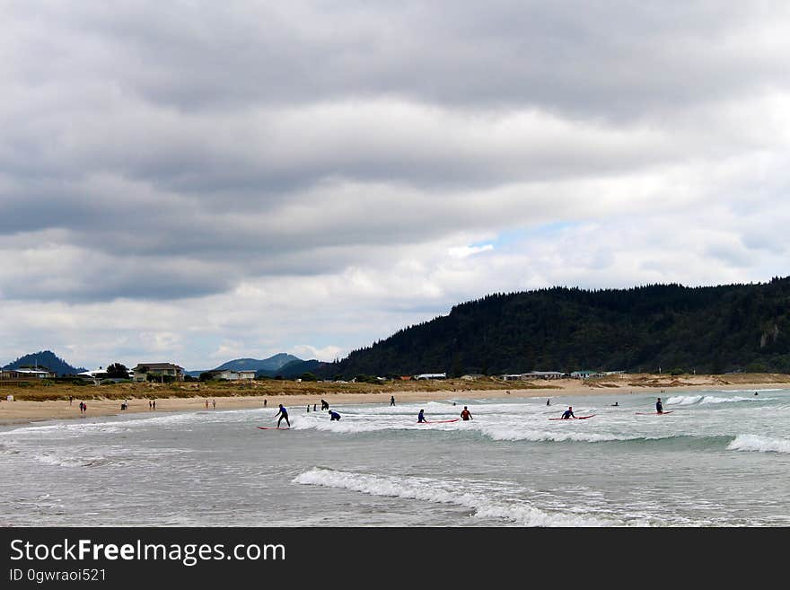 People surfing on Whangamata beach in New Zealand. People surfing on Whangamata beach in New Zealand.