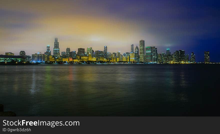 Waterfront city skyline illuminated at dawn. Waterfront city skyline illuminated at dawn.