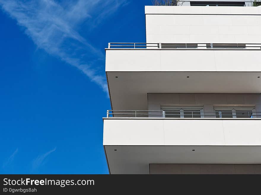 A generic apartment building with balconies against the blue sky. A generic apartment building with balconies against the blue sky.