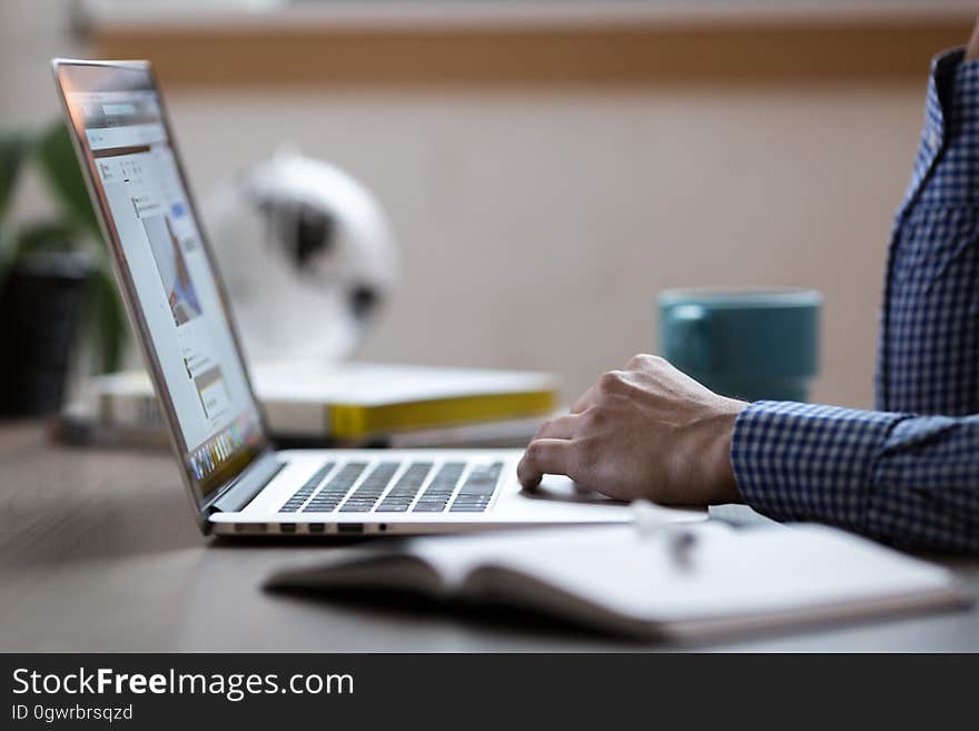 A person working on a laptop computer. A person working on a laptop computer.