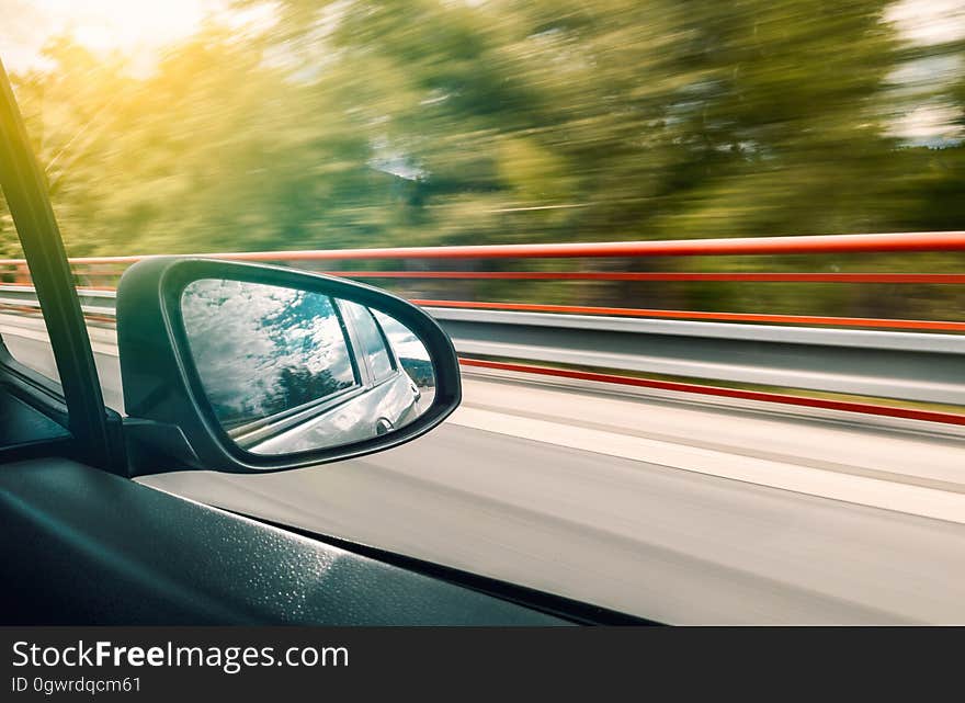 A car speeding down on a highway. A car speeding down on a highway.