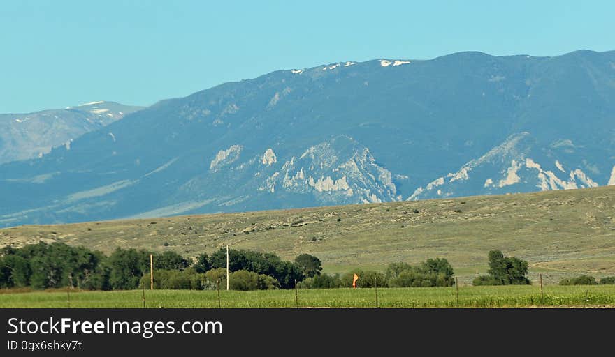 A view of a field and mountains in the background.